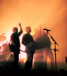 a group of people standing on top of a stage with microphones in front of them