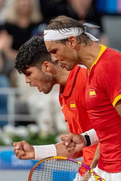 two tennis players holding racquets in their hands and yelling at each other