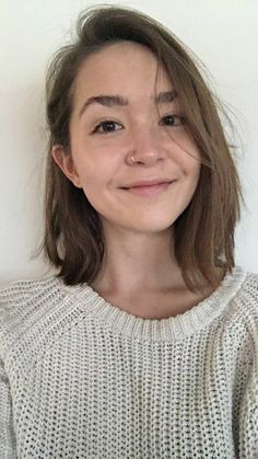 a woman with brown hair is smiling at the camera