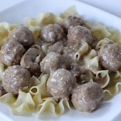 a white plate topped with meatballs and noodles