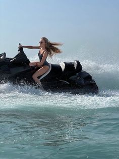 a woman riding on the back of a jet ski