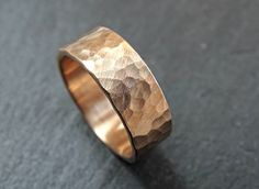 a wedding ring made out of gold and silver with a textured design on it