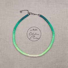 a green and white beaded necklace on a gray background with the words peace love written across it