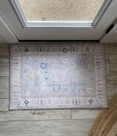 an area rug is on the floor in front of a door with a skylight