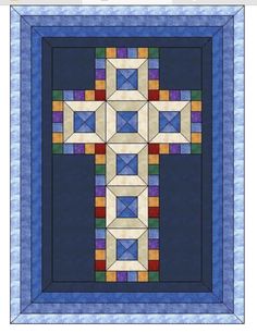 a blue and white quilt with a cross on it's center, in the middle