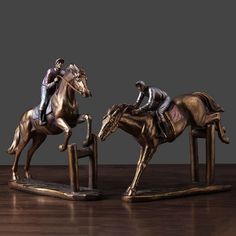 two figurines of horses and jockeys on wooden table with dark background,