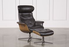 a black leather reclining chair and footstool in front of a white wall