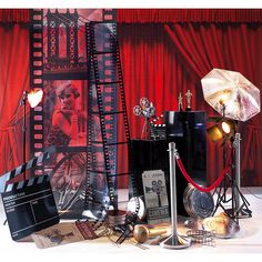 an assortment of movie memorabilia on display in front of a red curtain and stage backdrop