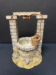 a miniature fountain with a basket on it