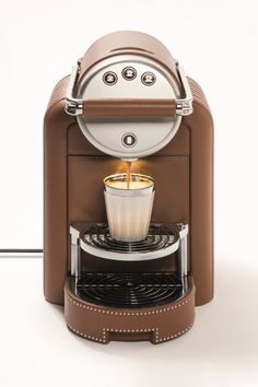 an espresso machine is shown with its light on and coffee in the cup