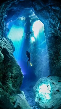 a person swimming in an underwater cave