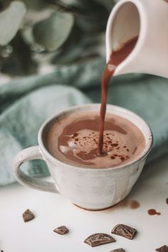 chocolate being poured into a white mug