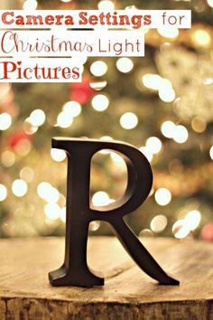 the letter r is placed on top of a tree stump in front of a christmas tree