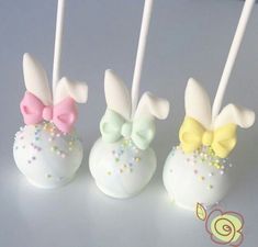 three cake pops decorated with bows and sprinkles