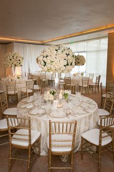 the wedding reception table is set up with white flowers