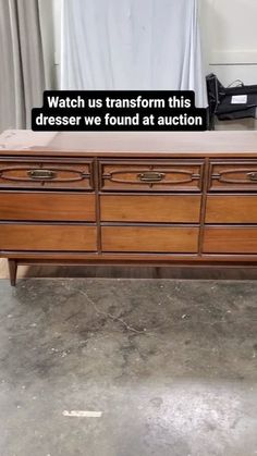 a large wooden dresser sitting on top of a floor next to a window with the words watch us transform this dresser we found at auction