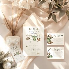 the wedding stationery is laid out next to some flowers and greenery, including an ornament