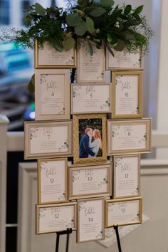 an arrangement of framed photos and greenery is displayed on a easel at the reception