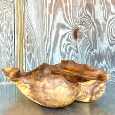 a wooden bowl sitting on top of a metal table