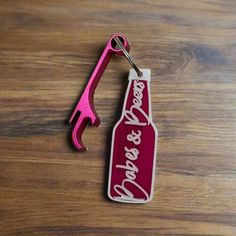 a bottle shaped keychain with the word coca - cola and a wrench