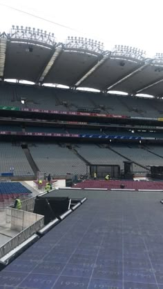 an empty stadium filled with lots of seats and tarp covering the floor in front of it