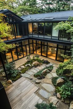 an aerial view of a house in the woods with trees and rocks on the ground