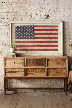 an american flag is hanging on the wall next to a dresser with drawers and a potted plant