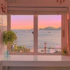 a window with a view of the ocean and boats out to sea in the distance