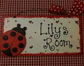 a red and white sign with a ladybug sitting on it's side