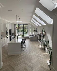 a kitchen and living room are separated by an open floor plan, with skylights