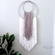 a wall hanging with two circular rings and tassels