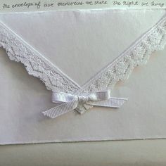 an envelope decorated with white lace and ribbon