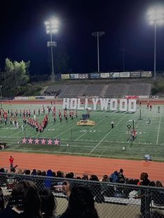 the hollywood high school marching team is performing on the field in front of an empty bleachers