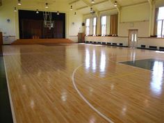 an empty gym with hard wood floors and high ceilings