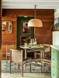 a kitchen with green cabinets and wooden walls