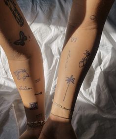 two people with tattoos on their arms and legs, both holding each other's hands