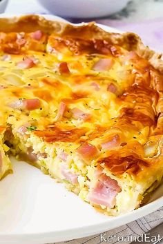 a ham and cheese quiche on a white plate