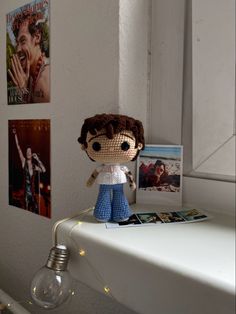 a stuffed doll sitting on top of a white desk next to a lightbulb