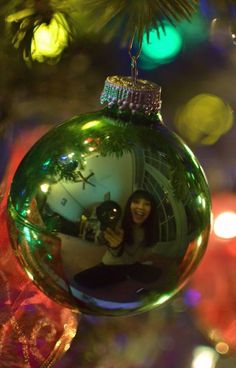 a christmas ornament with a woman taking a selfie in front of it