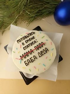 a birthday cake with frosting and sprinkles sitting on a napkin next to a christmas ornament