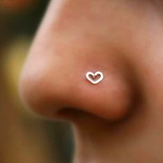 a woman's nose with a heart shaped nose ring on it, as seen from the side