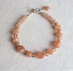 Lovely, faceted, brownish-pink 9.5 mm and 8.5 mm Sunstone gemstones with matching Czech Crystal faceted glass beads on an extender bracelet. The small rondelle beads are Agate. The bead caps, clasp and extender are solid Sterling Silver .925. Length: adjustable to fit 17.5 - 19.5 cm wrist. All jewellery is delivered gift-wrapped. You receive the exact item pictured. Contact me with any questions or issues. Czech Crystal, Faceted Glass, Bead Caps, Gemstone Bracelet, Arm Band, Glass Beads, Agate, Jewelry Bracelets, Beaded Bracelets