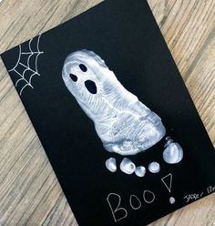 a halloween card with a ghost handprinted on it and some balls in the background