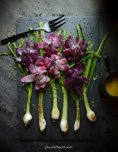 purple flowers and green stems on a cutting board