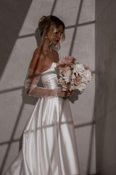 a woman in a wedding dress holding a bouquet