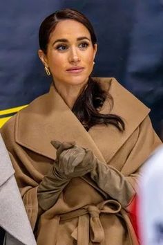 the woman is wearing a brown coat and tan gloves