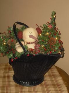 a teddy bear sitting in a basket with christmas decorations on it's table top