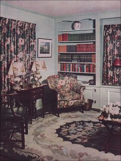 a living room filled with furniture and bookshelves next to a window covered in curtains