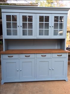 a blue china cabinet with glass doors and drawers