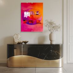 an abstract painting hangs on the wall next to a console